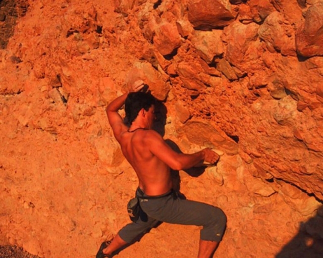 foto naranja de un hombre escalando por una montana